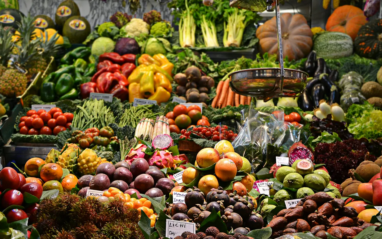 Barracas de uma feira ao ar livre, com frutas e flores